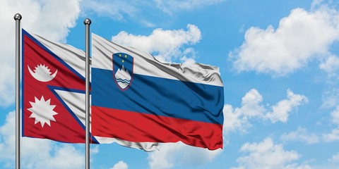 Nepal and Slovenia flag waving in the wind against white cloudy blue sky together. Diplomacy concept, international relations.