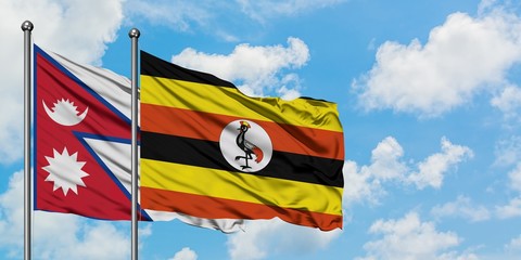 Nepal and Uganda flag waving in the wind against white cloudy blue sky together. Diplomacy concept, international relations.