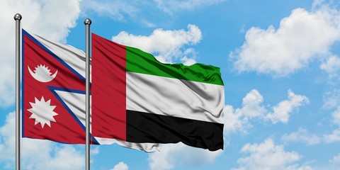 Nepal and United Arab Emirates flag waving in the wind against white cloudy blue sky together. Diplomacy concept, international relations.