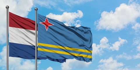 Netherlands and Aruba flag waving in the wind against white cloudy blue sky together. Diplomacy concept, international relations.