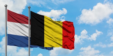 Netherlands and Belgium flag waving in the wind against white cloudy blue sky together. Diplomacy concept, international relations.