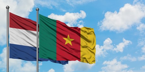 Netherlands and Cameroon flag waving in the wind against white cloudy blue sky together. Diplomacy concept, international relations.