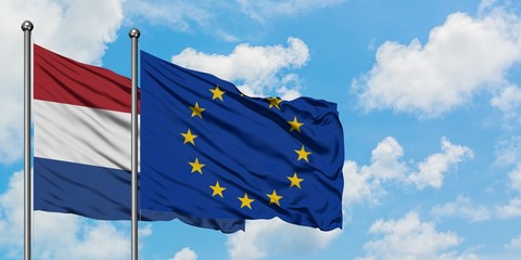Netherlands and European Union flag waving in the wind against white cloudy blue sky together. Diplomacy concept, international relations.