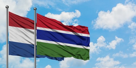 Netherlands and Gambia flag waving in the wind against white cloudy blue sky together. Diplomacy concept, international relations.