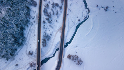 Country road going through the beautiful snow covered landscapes. Aerial view. Drone photography