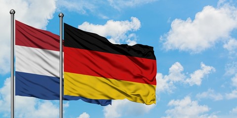 Netherlands and Germany flag waving in the wind against white cloudy blue sky together. Diplomacy concept, international relations.