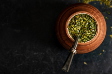 Beautiful composition of yerba mate on a black background - Juicy and green leaves without sticks