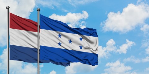 Netherlands and Honduras flag waving in the wind against white cloudy blue sky together. Diplomacy concept, international relations.