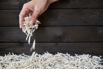Woman's hand holding handmade noodles and pours its on the table. Closeup, selective focus