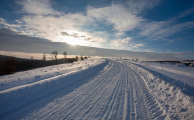 Empty snow covered road in winter landscape