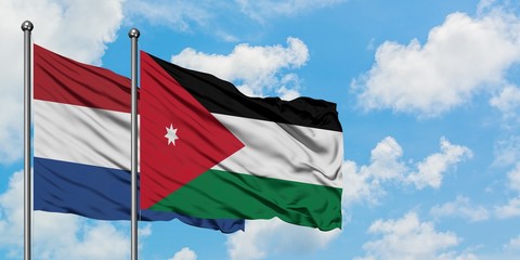 Netherlands and Jordan flag waving in the wind against white cloudy blue sky together. Diplomacy concept, international relations.