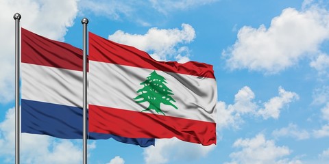 Netherlands and Lebanon flag waving in the wind against white cloudy blue sky together. Diplomacy concept, international relations.