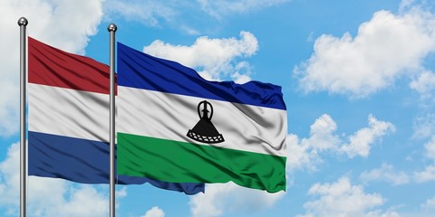 Netherlands and Lesotho flag waving in the wind against white cloudy blue sky together. Diplomacy concept, international relations.