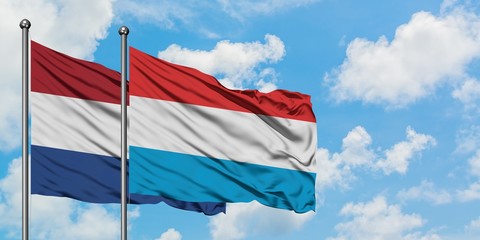 Netherlands and Luxembourg flag waving in the wind against white cloudy blue sky together. Diplomacy concept, international relations.