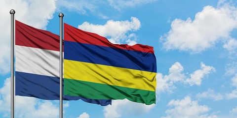 Netherlands and Mauritius flag waving in the wind against white cloudy blue sky together. Diplomacy concept, international relations.