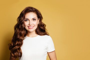 Fototapeta premium Piękna kobieta ubrana w białą koszulkę na żółtym tle