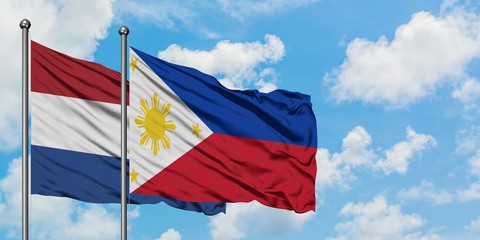 Netherlands and Philippines flag waving in the wind against white cloudy blue sky together. Diplomacy concept, international relations.