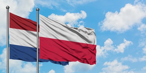 Netherlands and Poland flag waving in the wind against white cloudy blue sky together. Diplomacy concept, international relations.