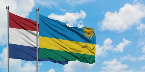 Netherlands and Rwanda flag waving in the wind against white cloudy blue sky together. Diplomacy concept, international relations.