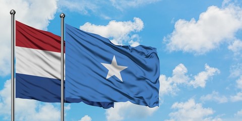 Netherlands and Somalia flag waving in the wind against white cloudy blue sky together. Diplomacy concept, international relations.