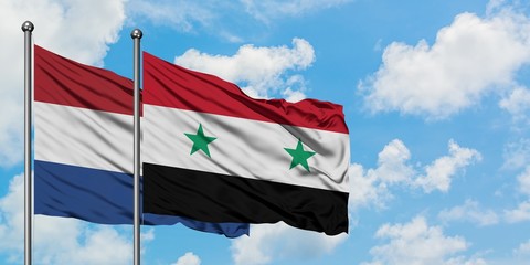 Netherlands and Syria flag waving in the wind against white cloudy blue sky together. Diplomacy...