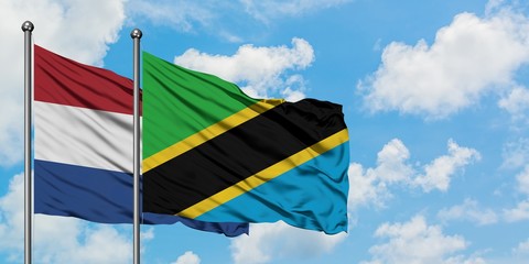 Netherlands and Tanzania flag waving in the wind against white cloudy blue sky together. Diplomacy concept, international relations.