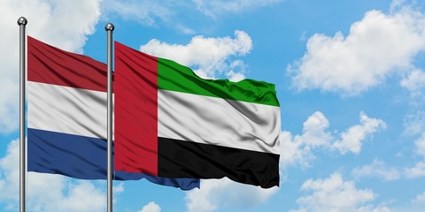 Netherlands and United Arab Emirates flag waving in the wind against white cloudy blue sky together. Diplomacy concept, international relations.