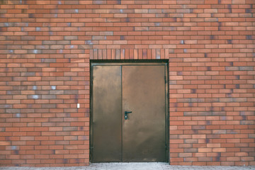 Texture of red brick wall and brown iron door
