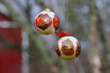 A white Christmas ball with red decorations hanging in the air