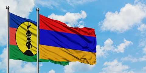 New Caledonia and Armenia flag waving in the wind against white cloudy blue sky together. Diplomacy concept, international relations.