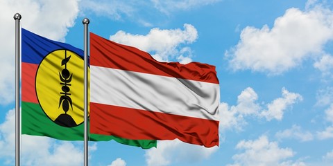 New Caledonia and Austria flag waving in the wind against white cloudy blue sky together. Diplomacy concept, international relations.