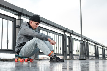 Sad teenager is sitting on the street. Depression