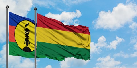 New Caledonia and Bolivia flag waving in the wind against white cloudy blue sky together. Diplomacy concept, international relations.