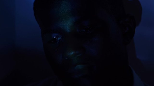 Young black man stoned in the disco with psychedelic lights