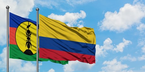 New Caledonia and Colombia flag waving in the wind against white cloudy blue sky together. Diplomacy concept, international relations.