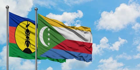 New Caledonia and Comoros flag waving in the wind against white cloudy blue sky together. Diplomacy concept, international relations.