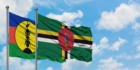 New Caledonia and Dominica flag waving in the wind against white cloudy blue sky together. Diplomacy concept, international relations.