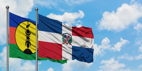 New Caledonia and Dominican Republic flag waving in the wind against white cloudy blue sky together. Diplomacy concept, international relations.