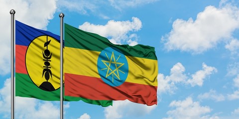 New Caledonia and Ethiopia flag waving in the wind against white cloudy blue sky together. Diplomacy concept, international relations.