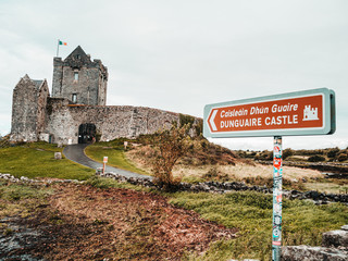 Historic Dunguaire castle moody scenery with tourist sign 