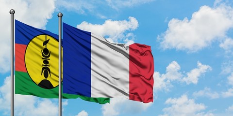 New Caledonia and France flag waving in the wind against white cloudy blue sky together. Diplomacy concept, international relations.
