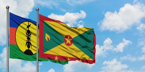 New Caledonia and Grenada flag waving in the wind against white cloudy blue sky together. Diplomacy concept, international relations.