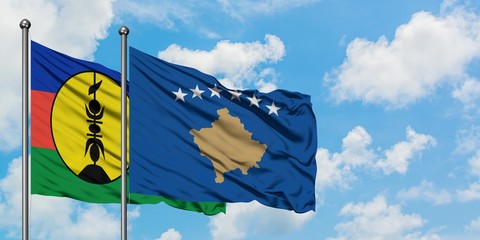 New Caledonia and Kosovo flag waving in the wind against white cloudy blue sky together. Diplomacy concept, international relations.