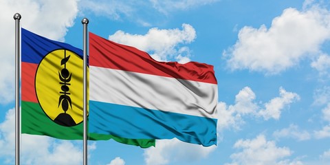 New Caledonia and Luxembourg flag waving in the wind against white cloudy blue sky together. Diplomacy concept, international relations.