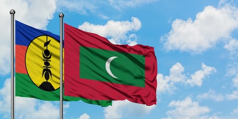 New Caledonia and Maldives flag waving in the wind against white cloudy blue sky together. Diplomacy concept, international relations.