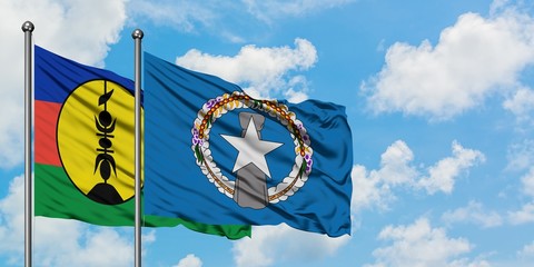New Caledonia and Northern Mariana Islands flag waving in the wind against white cloudy blue sky together. Diplomacy concept, international relations.