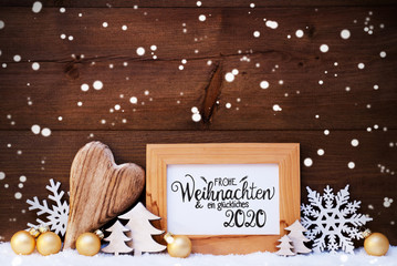 German Calligraphy Frohe Weihnachten Und Ein Glueckliches 2020 Mean Merry Christmas And Happy 2020. Golden Christmas Ornament Like Ball, Heart And Tree. Wooden Background With Snow And Snowflakes