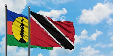 New Caledonia and Trinidad And Tobago flag waving in the wind against white cloudy blue sky together. Diplomacy concept, international relations.
