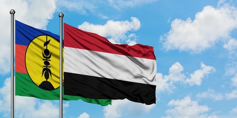 New Caledonia and Yemen flag waving in the wind against white cloudy blue sky together. Diplomacy concept, international relations.
