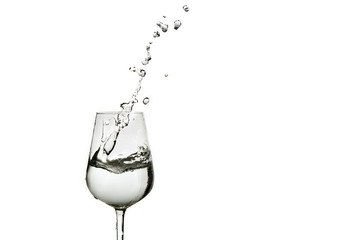beautiful splashes of water in a wine glass, isolate on white, close up with copy space.